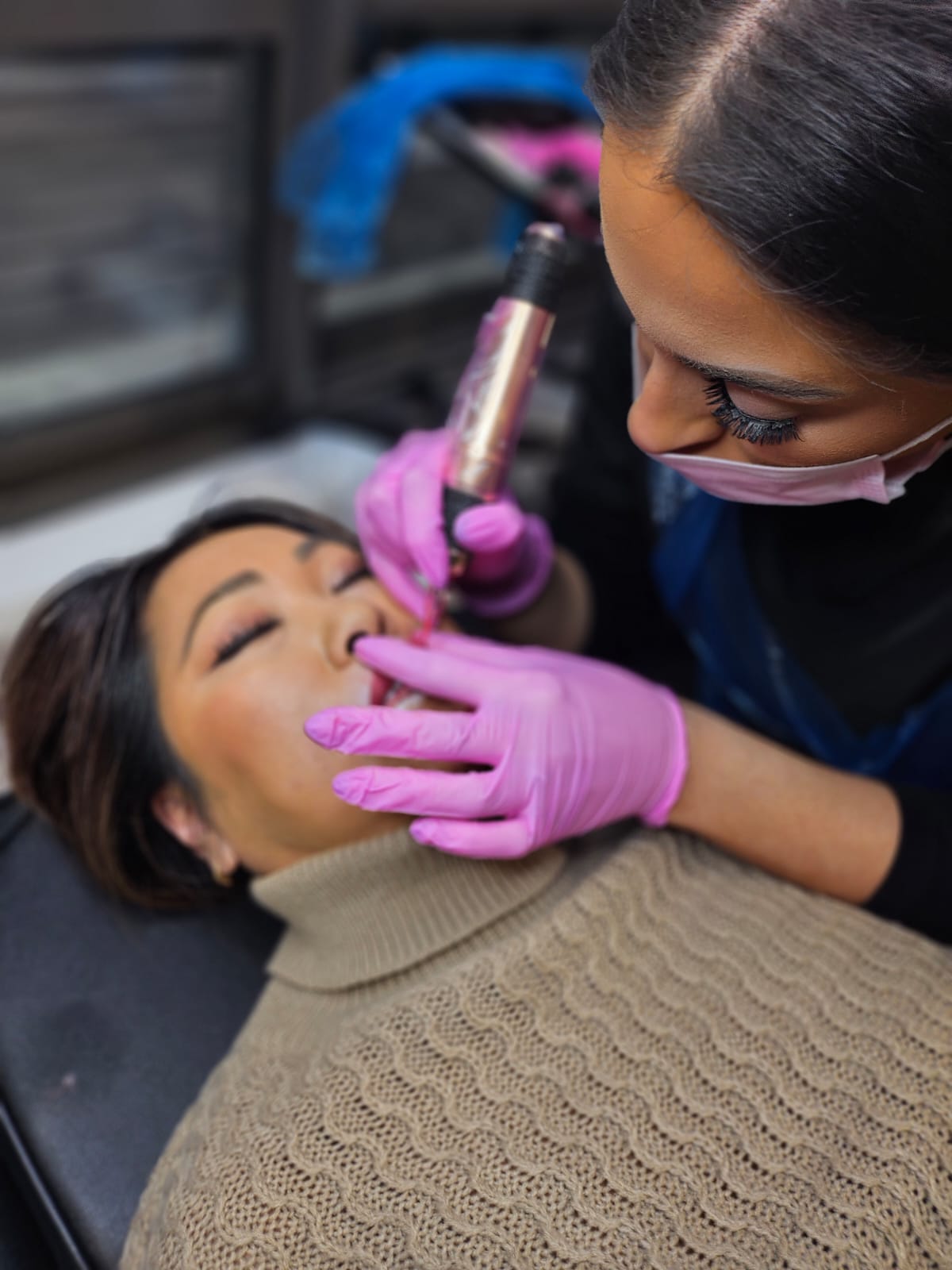 Student performing a lip blush treatment on a live model